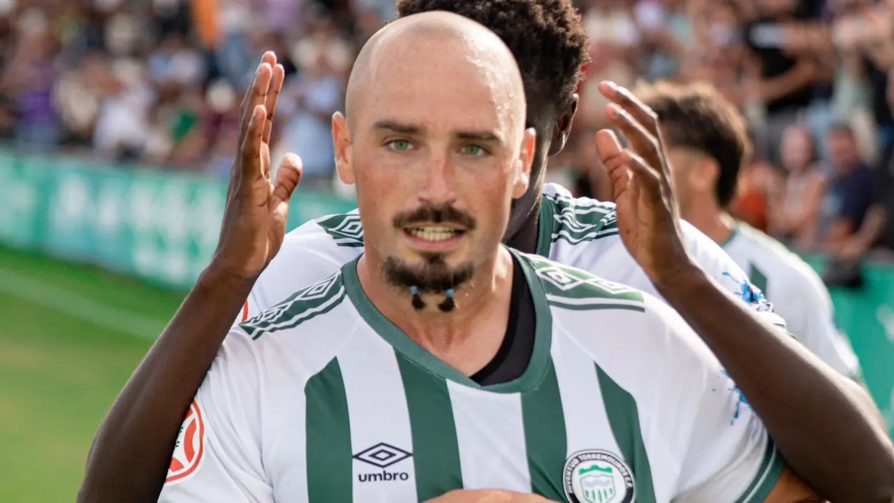 Javi M&eacute;rida se&ntilde;al&aacute;ndose el escudo / Foto: Juventud Torremolinos